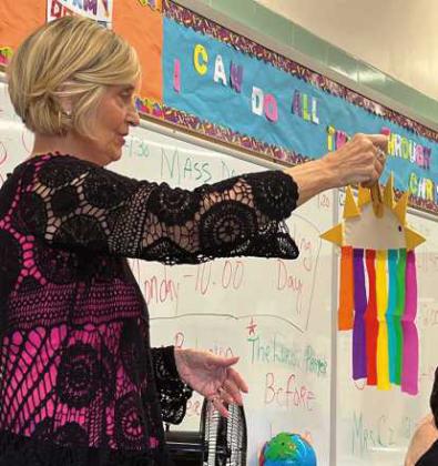 Christ Child Society member, Sue Borer, explains one of the craft projects during the classroom visit at Gesu Elementary School. She is a Holland resident.