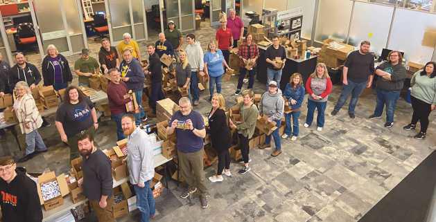 The McAlear Group held an “Operation Holiday Drop” where gift boxes were packed to be sent to active members of the military. Above is the packing assembly line.