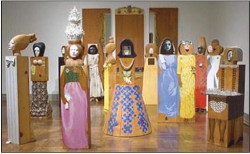 The exhibit includes “The Party,” an assemblage of 15 freestanding, life-size figures and three wall panels, with painted wood and carved wood, mirrors, plastic, television set, clothes, shoes, glasses and other accessories.