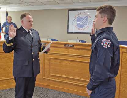 Acting Chief Ziehr, left, administers the oath of office to fulltime firefighter/paramedic Michael Henry.